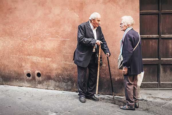 An elderly man and woman talking on the street