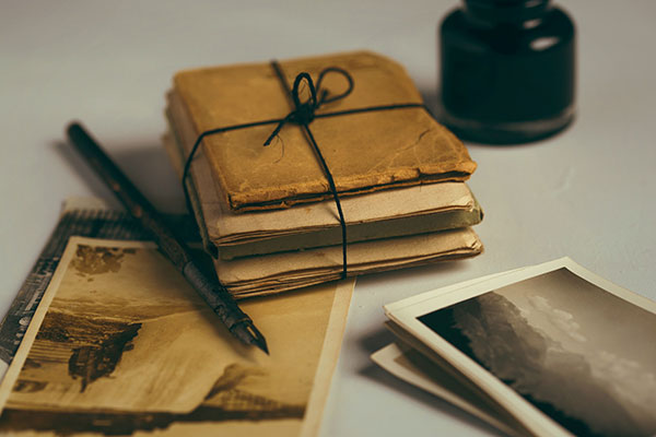 Brown paper packages tied up with string, old photos, a pen and ink