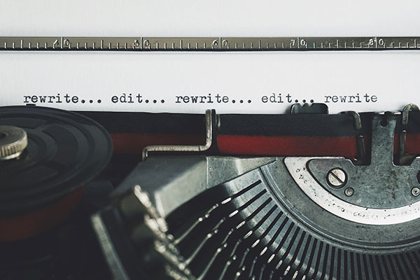 A typewriter with the words "rewrite... edit...rewrite... edit... rewrite..." typed on the paper